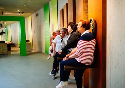 Senioren lauschen Audioguide in Ausstellung