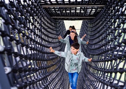 Familie in Klettertunnel im Erlebnisturm Höhlenblick bei der Fundstelle