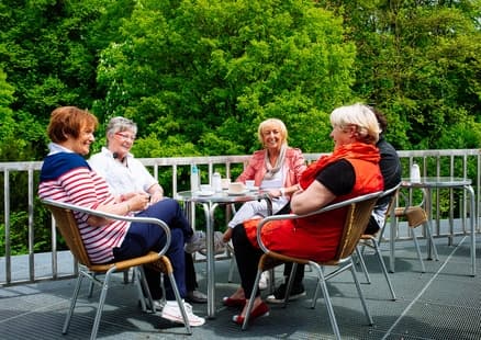 Erwachsene sitzen auf Dachterasse des Museumscafes