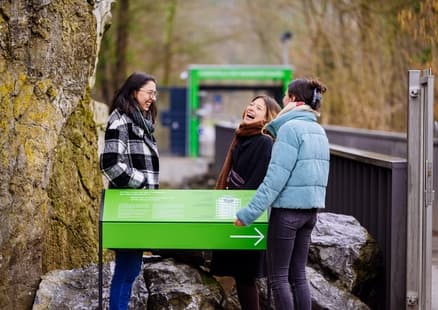 Erwachsene stehen an Schild bei Fundstelle in Outdoor Erlebniswelt