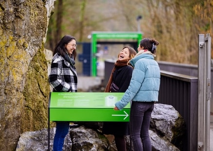 Erwachsene stehen an Schild bei Fundstelle in Outdoor Erlebniswelt
