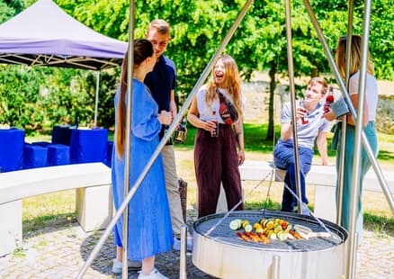 Gastronomie bei Firmen und Teamevents, Erwachsene stehen an Grillstelle