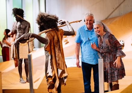 Erwachsene mit Audioguides zwischen Homo sapiens sapiens und Homo ergaster