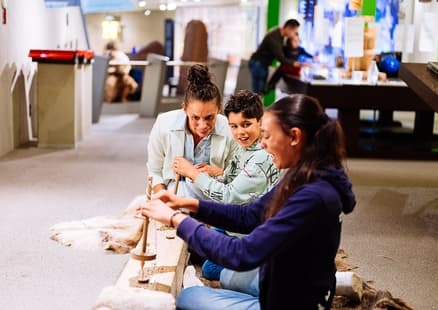 In Ausstellung bohren Kinder Löcher mit Steinzeitbohrer aus Steinzeit Action Pack