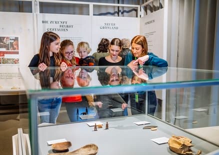 Familie bestaunt Inuit Werkzeuge in Sonderausstellung Eiszeitreise Grönland