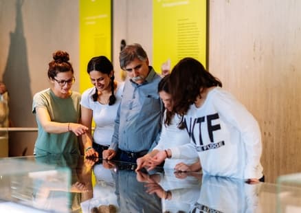 Erwachsene betrachten Grabungsstation in Vitrine in Ausstellung