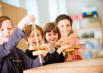 Kinder mit Steinzeitbohrer bei Steinzeitamulett Workshop im Steinzeitgeburtstag