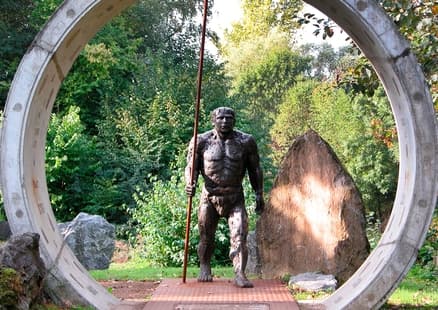 Neanderthaler Skulptur aus Stein in der Natur auf dem Evolutionspfad Neandertal