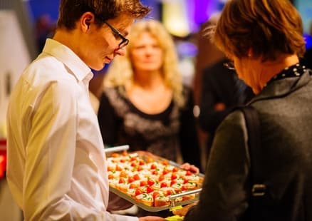 Person serviert Fingerfood bei Firmen- und Teamevents