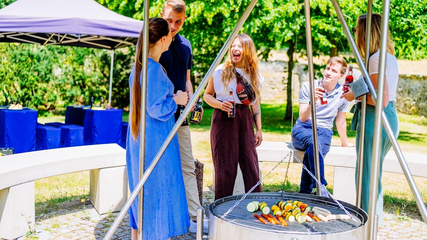 Gastronomie bei Firmen und Teamevents, Erwachsene stehen an Grillstelle